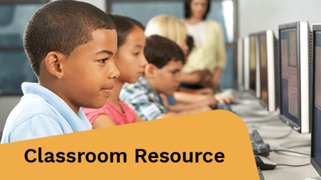 Elementary Students Working At Computers In Classroom Using Keyboard Concentrating