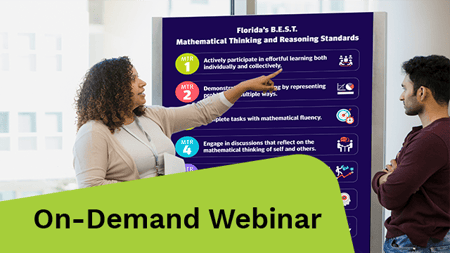 A diverse group of young adult college students gather around as the teacher points to the whiteboard and lectures.