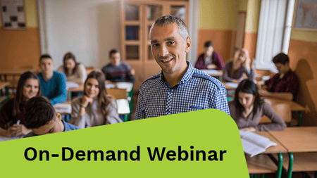 Happy high school teacher looking at camera during the class in the classroom.