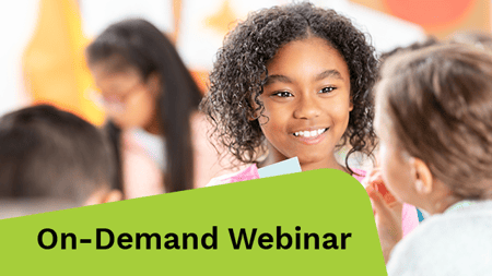 Young girl happily participates in math lesson with classmates in a bright classroom.