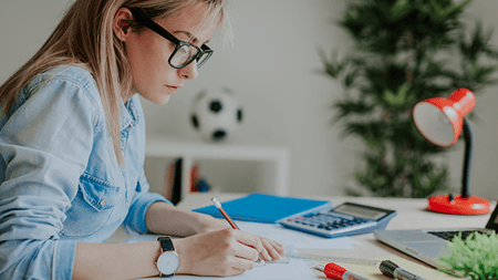 Girl with glasses doing homework at home