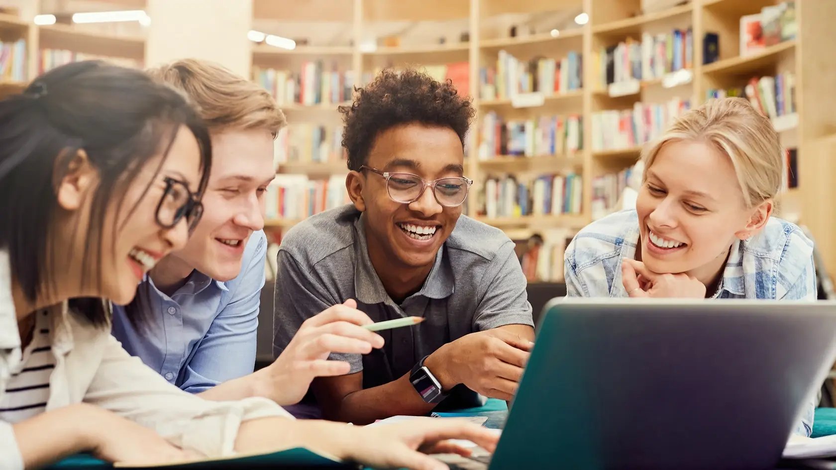 Students watching video on laptop in a library