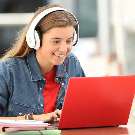 Happy student listening a video tutorial online with a laptop