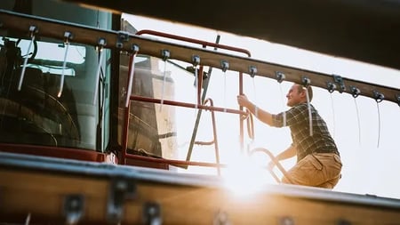 agricultural mechanic servicing farming equipment