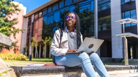 business college student using a laptop outdoors