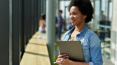 A successful female web designer holding digital tablet in the office hallway