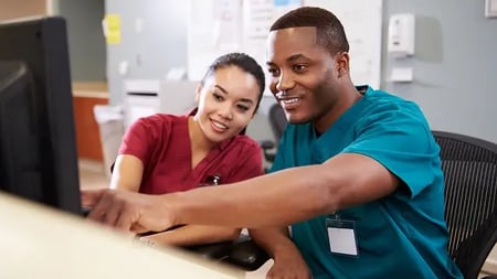 nursing assistants working together on a computer