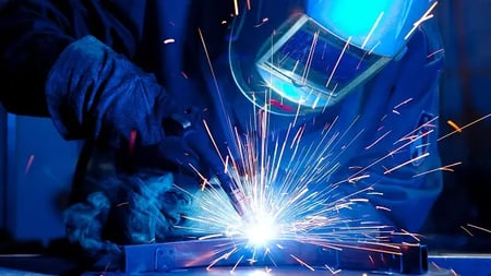 welder in full gear making a weld