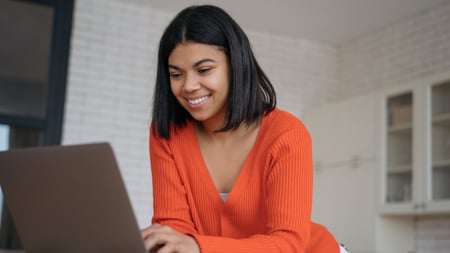 Young smiling woman using laptop computer watching training courses