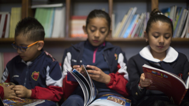 Classroom students flip through Our World program