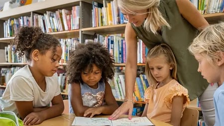 faculty helping young students in the library
