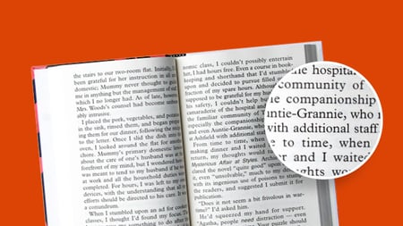 close up of a book with a magnifying glass on the page