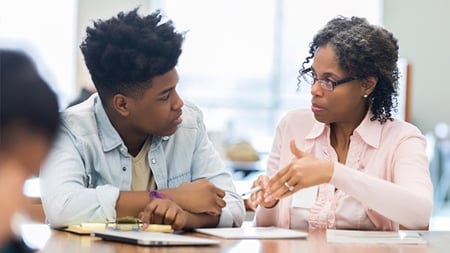 Teacher and student in a conversation in a classroom setting