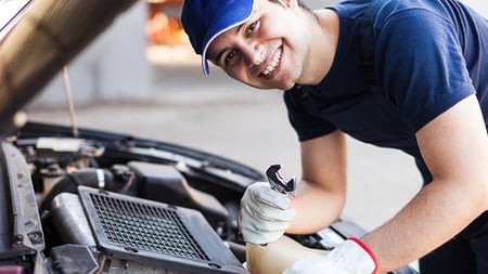 Smiling person working on a car