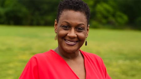 Woman in a red shirt smiling at the camera