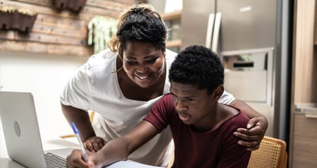  parent and student sitting in kitchen working at a laptop