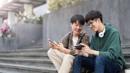 two students looking at their cell phones
