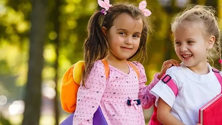 two small girls with pigtails and backpacks