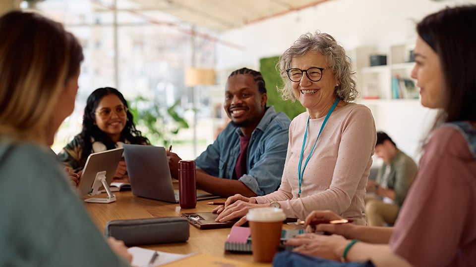 Happy mature professor and her students talking at casual study session