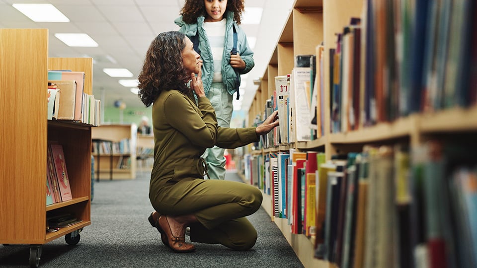 Girl, woman and search by bookshelf at library by shelf with learning, help and education in corridor.