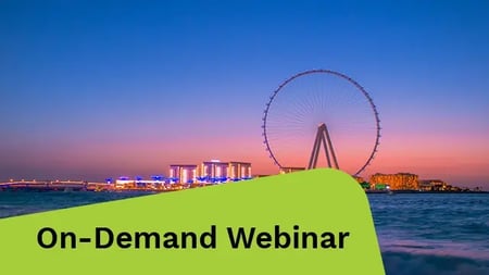 The Dubai Wheel at sunset, glowing with warm colors as the sun dips below the horizon.