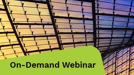 A clear sky is beautifully reflected in the glass roof of a contemporary building.